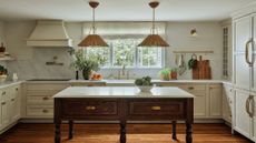 Freestanding farmhouse kitchen table styled in a characterful kitchen with ivory cabinetry and woven rattan pendant lights hanging overhead