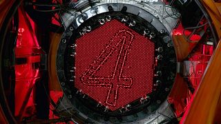 A photo of the face of a new fiber optic telescope with the number 4 over a red metal background is shown