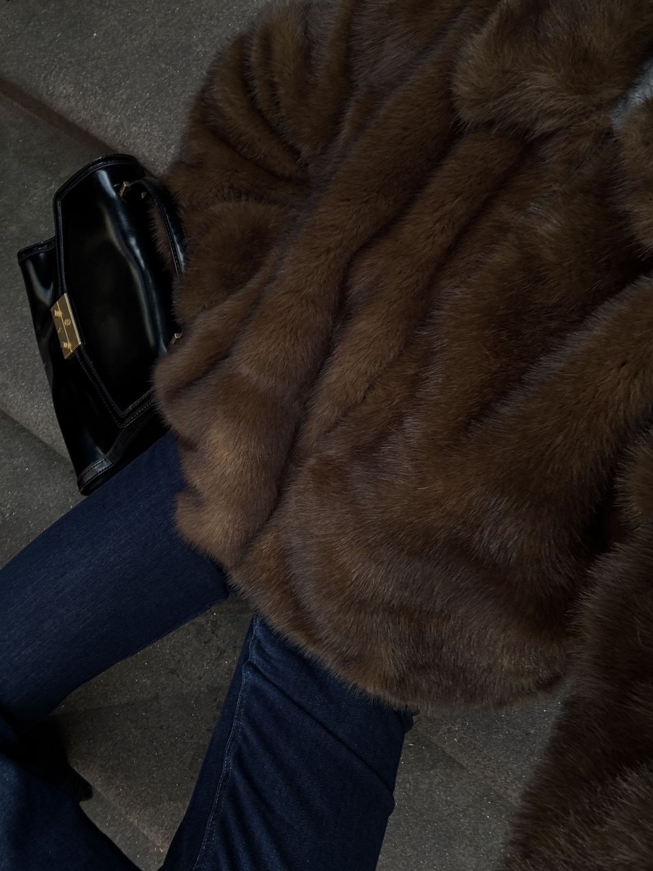 Kathryn Zahorak in a brown faux fur coat and dark jeans with black handbag