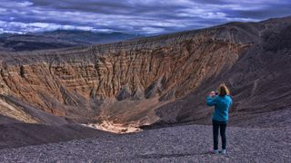 A hiker looking out at Ubehebe crater in Death Valley