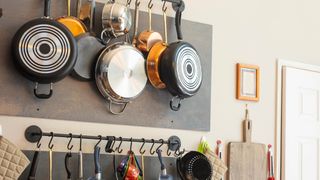 Pots and pans hanging on a wall rail