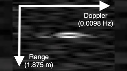 A pixilated black and white photo showing the radio signals given off by Integrity from 213,000 miles away and a pair of arrows pointing up and down with numbers next to them