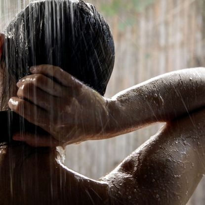 Woman washing her body under the shower