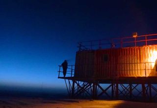 Artificial lights blaze in the growing twilight at Concordia station.