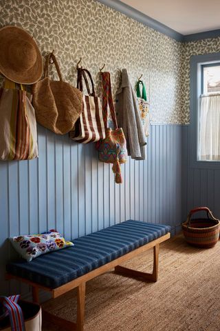 blue panelled hallway with bench and hooks