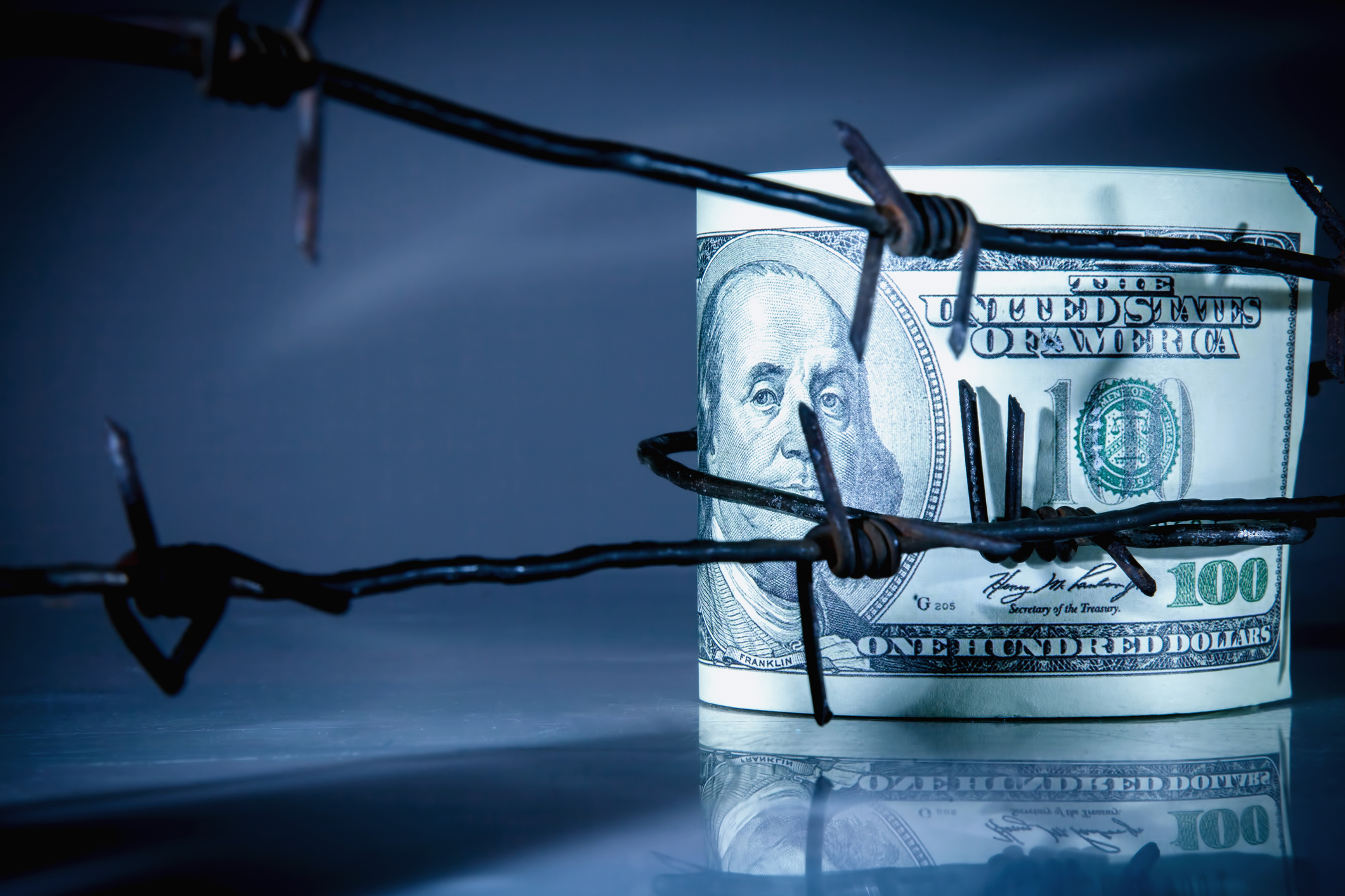 US hundred dollar bills wrapped in barbed wire for protection