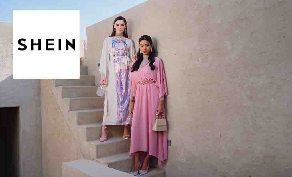 Shein logo placed over an image of two women posing in maxi dresses standing on a stone wall 
