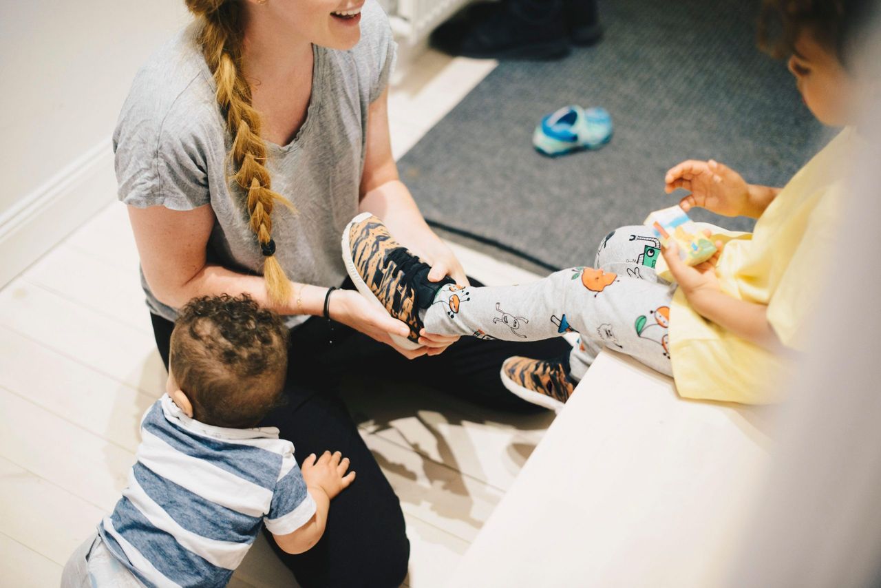 Mum choosing shoes for her toddler in a shop