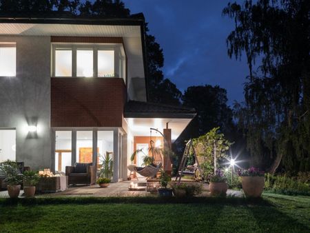 Nighttime exterior of a modern-looking house with light in every window