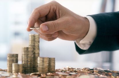 Hand of person wearing a suit, stacking coins