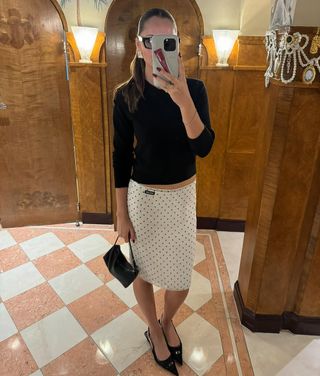 Pia Mance is wearing a Miu Miu polka dot skirt.