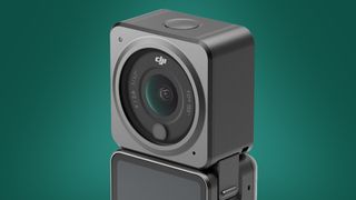 The DJI Action 2 action cam on a green background