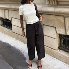woman wearing white top, black trousers and black kitten heels