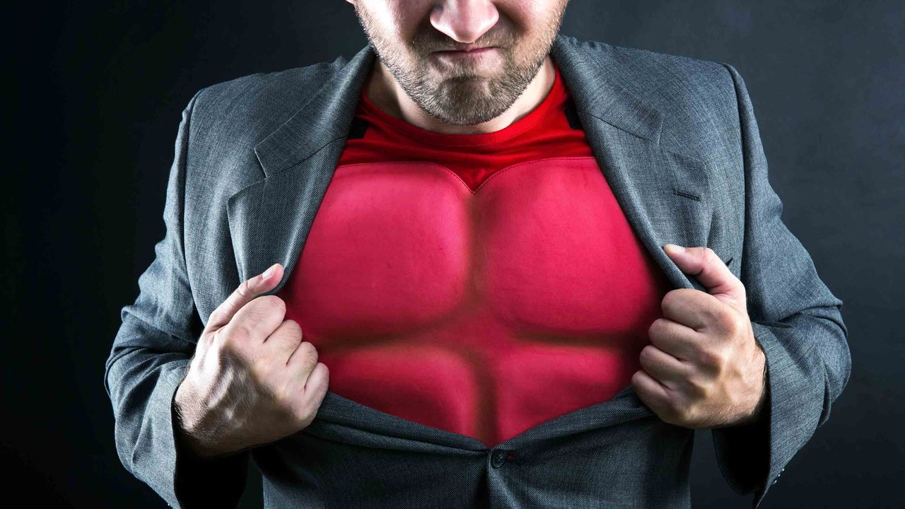 A businessman opening up his jacket to reveal a bulletproof superhuman body suit