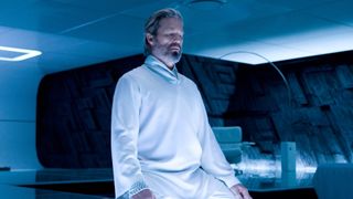 Jeff Bridges as Kevin Flynn wearing a white robe in his room during Tron: Legacy.