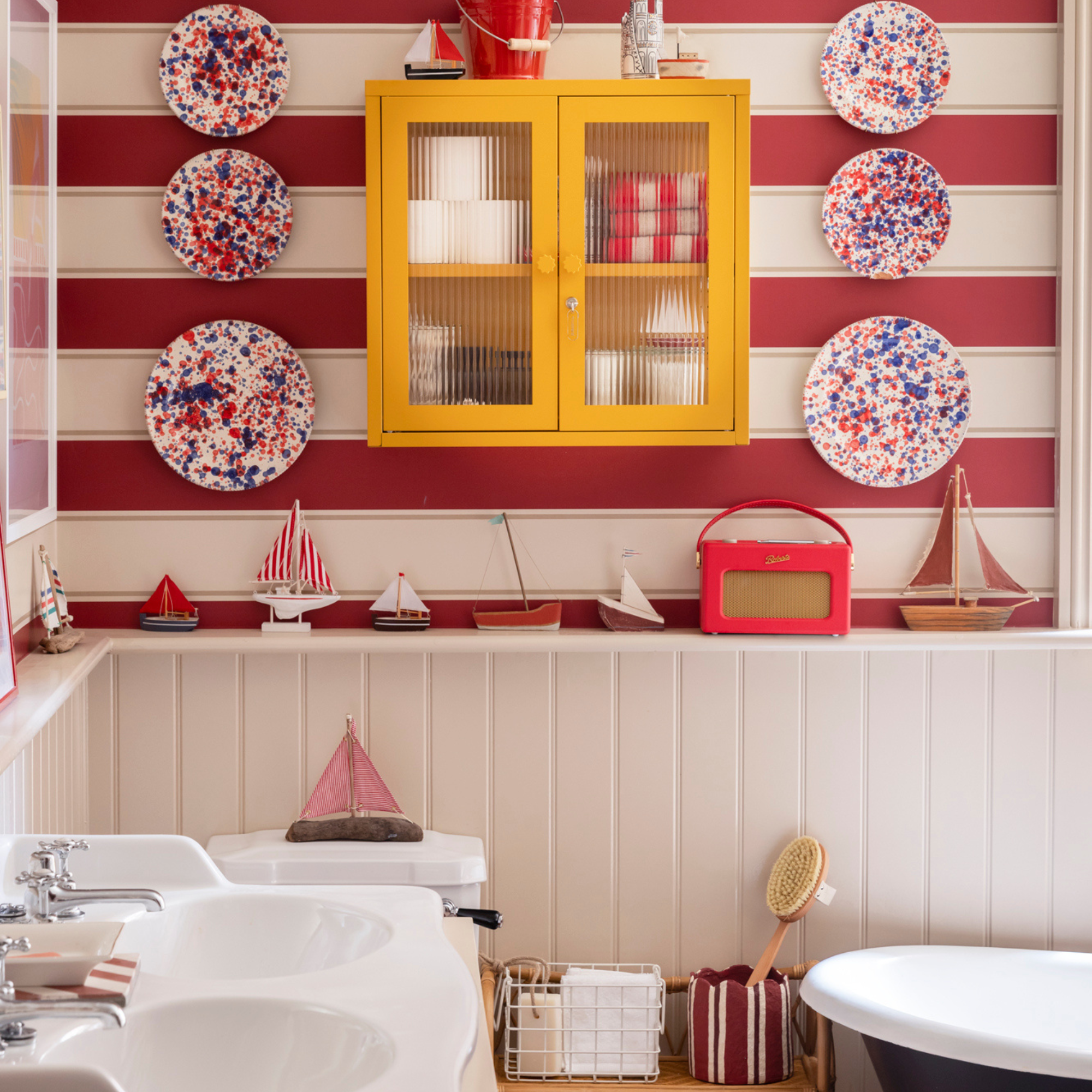 Red and white striped bathroom with yellow cabinet.