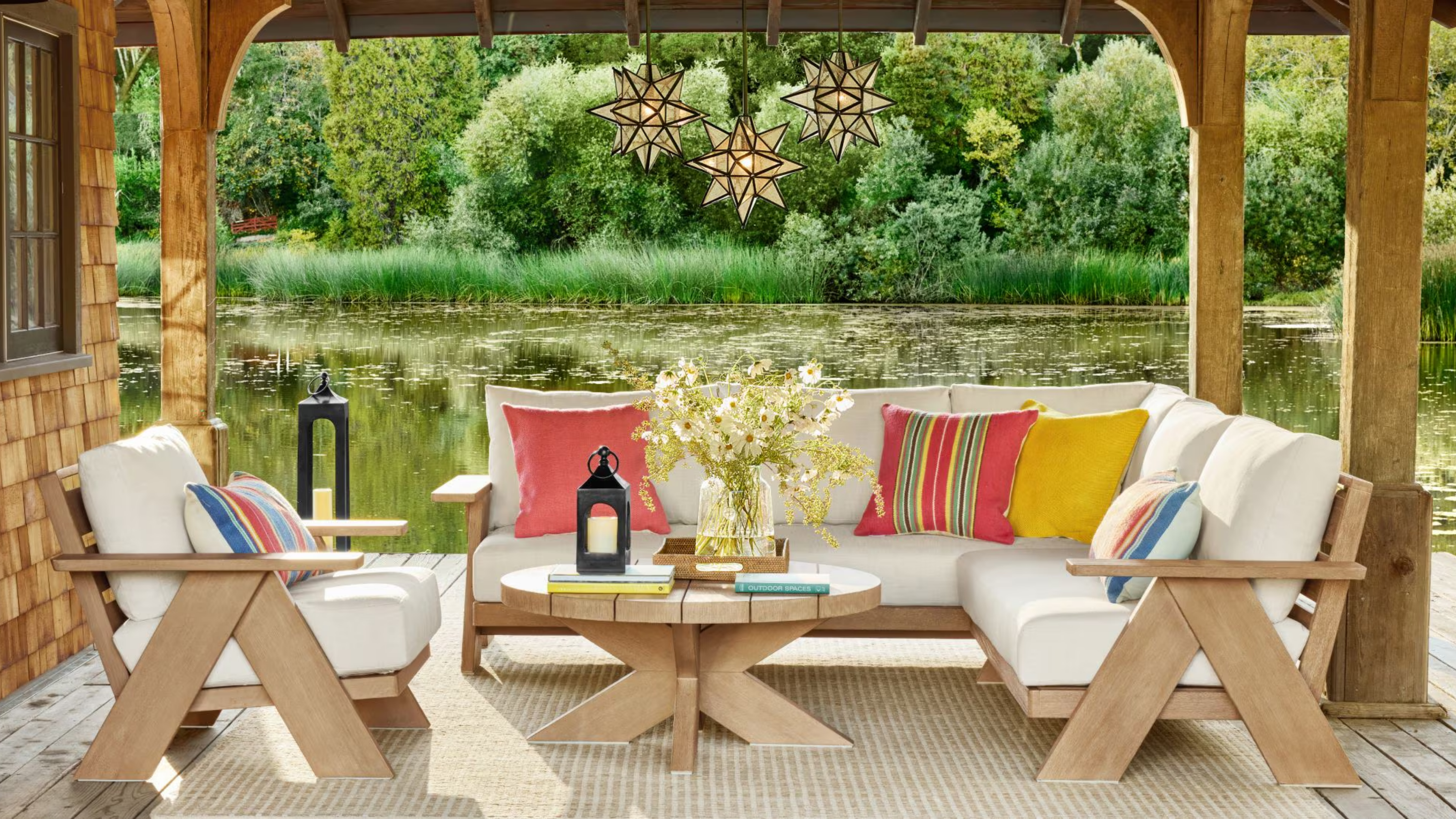 an outdoor living room on a dock next to a lake