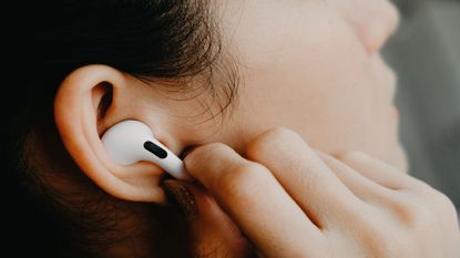 AirPods Pro worn by woman who is pressing the stalk