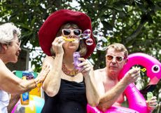 Older adults blowing bubbles by a pool