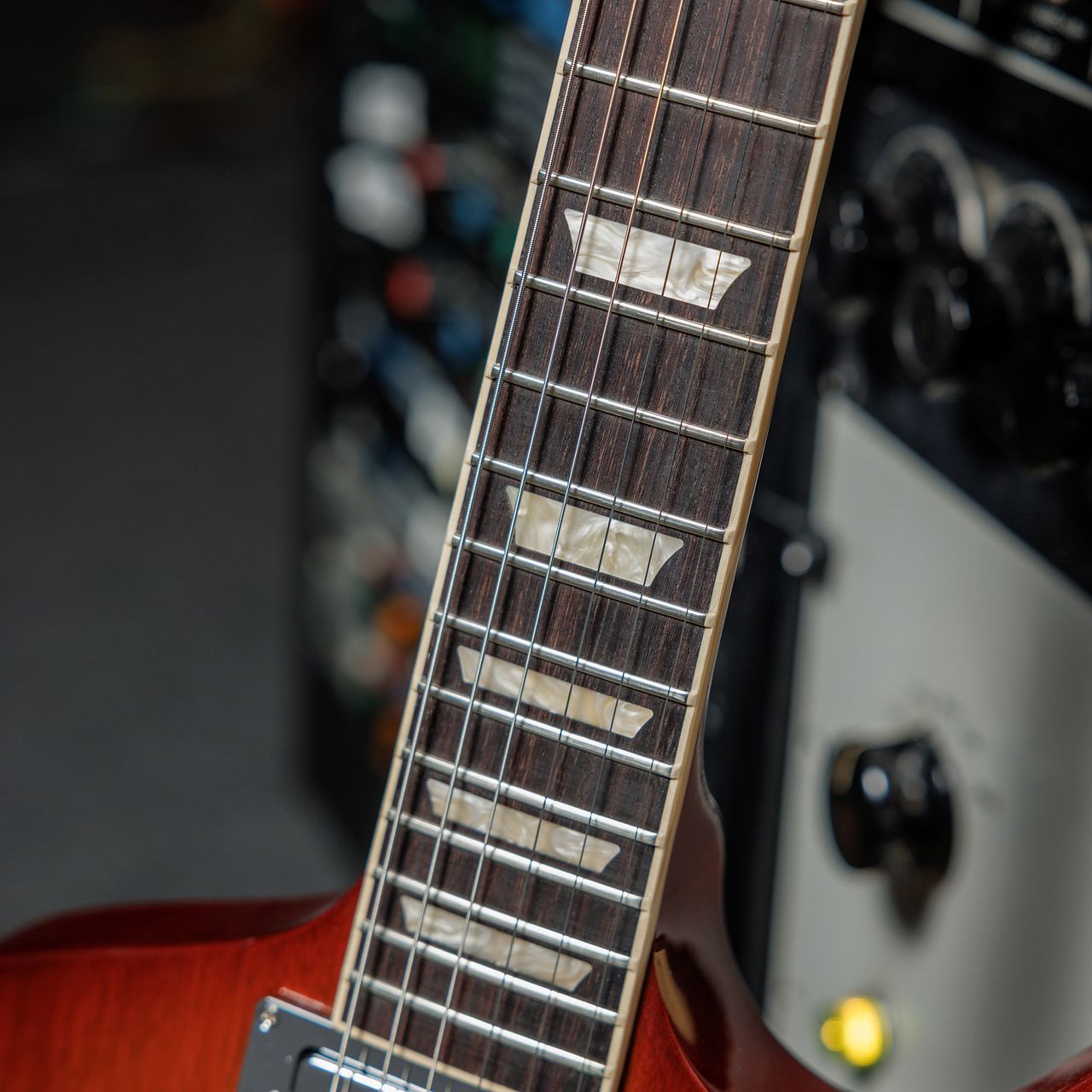 A photo showing a detail of the Gibson Firebird Platypus guitar in a recording studio setting