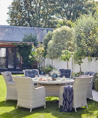 outdoor dining area with trees planted in a garden border