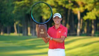 Collin Morikawa lifts the Zozo Championship trophy at Accordia Golf Narashino Country Club in Tokyo with a huge smile on his face