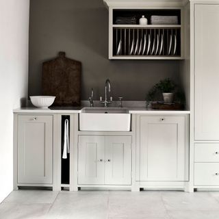 White cabinet with kitchen crockery and white walls
