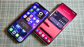 pixel 6 pro vs iphone 13 pro max: both faces laying face up with displays on showing home screens