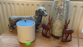 TP-Link Deco X55 mesh Wi-Fi router on a wooden table with decorations