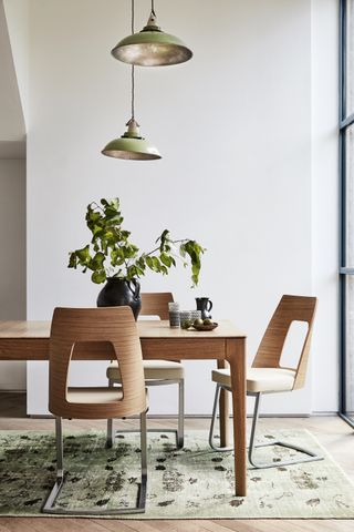 A dining room table with a light hanging directly above