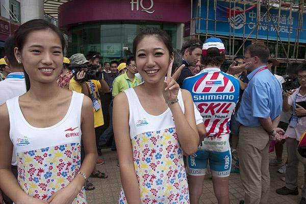 As the drama goes on behind tour podium girls await their duties in Dongfang.