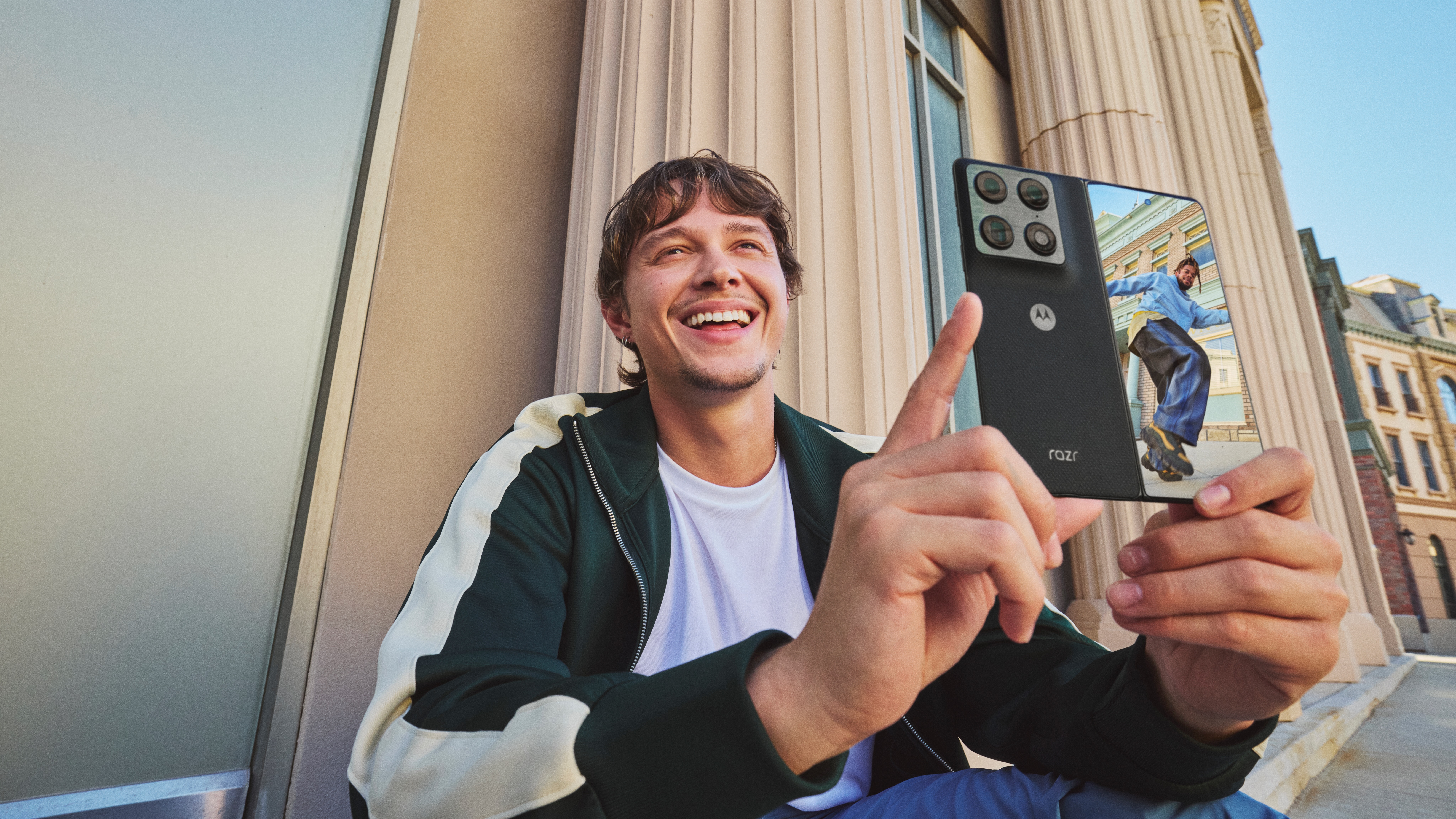 A young man showing a photo of a dancer on the outer screen of the Motorola Razr Fold