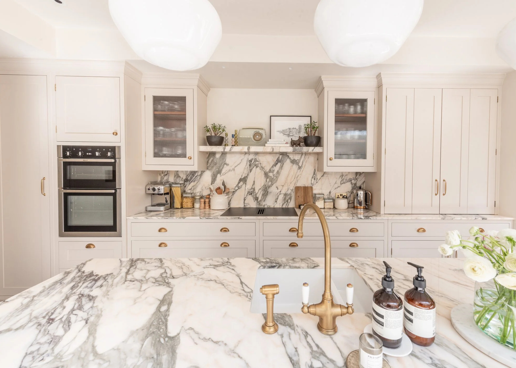 light gray kitchen cabinets mixed with white cabinets and a with marble splashback