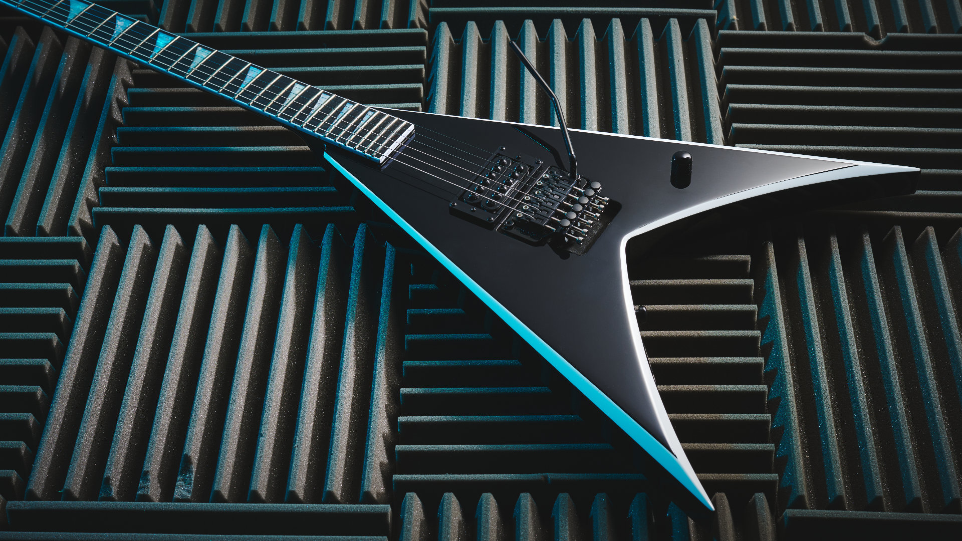 A Jackson Pro Series Signature Wes Borland King V lying on acoustic treatment panels