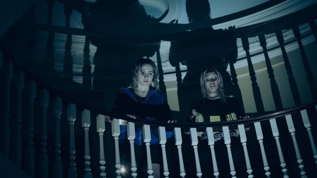 Maria Bakalova y Amandla Stenberg al pie de las escaleras en Bodies Bodies Bodies