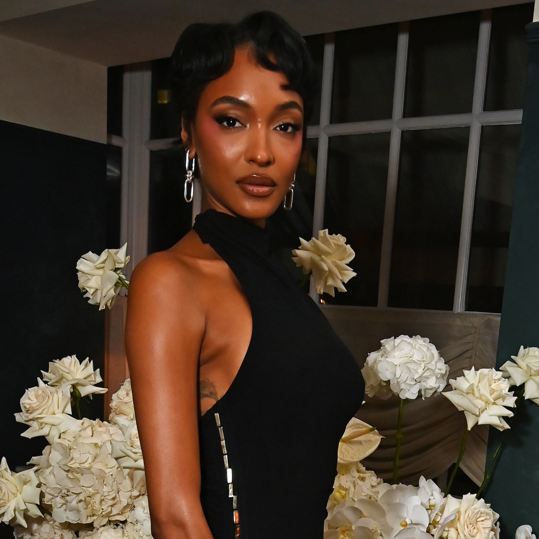 A woman with short hair that has finger waves in it, wearing a turtle neck halter top.