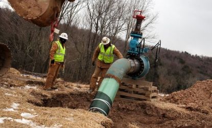 Men work on a natural gas valve at a hydraulic fracturing site in South Montrose, Penn.