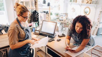 A small business owners goes through a checklist with her partner.