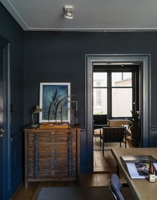 Farrow & Ball Railings, the best grey paint for darker, north-facing rooms, used in a dining room with a table and chest of drawers