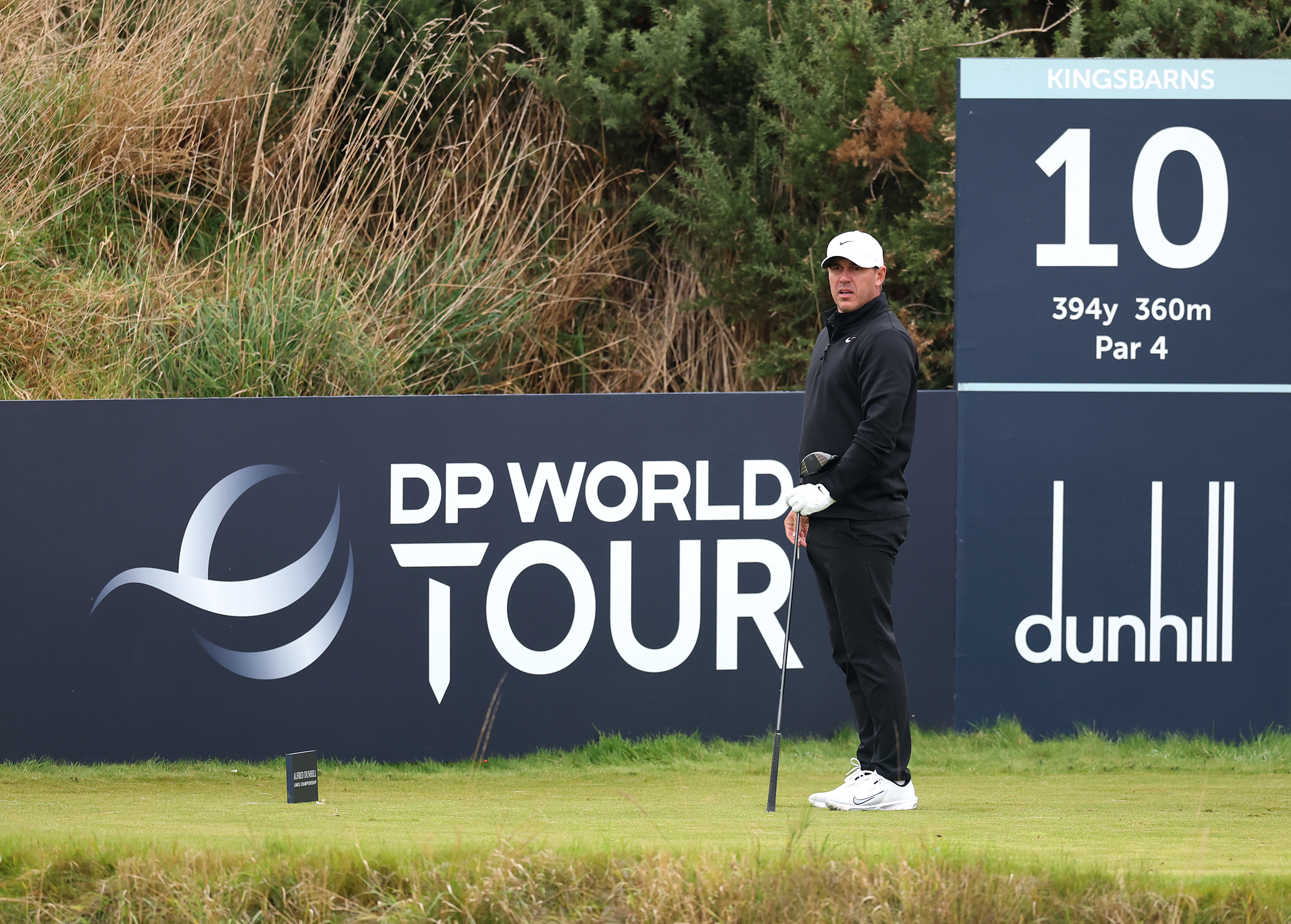 Brooks Koepka watches a tee shot with a driver