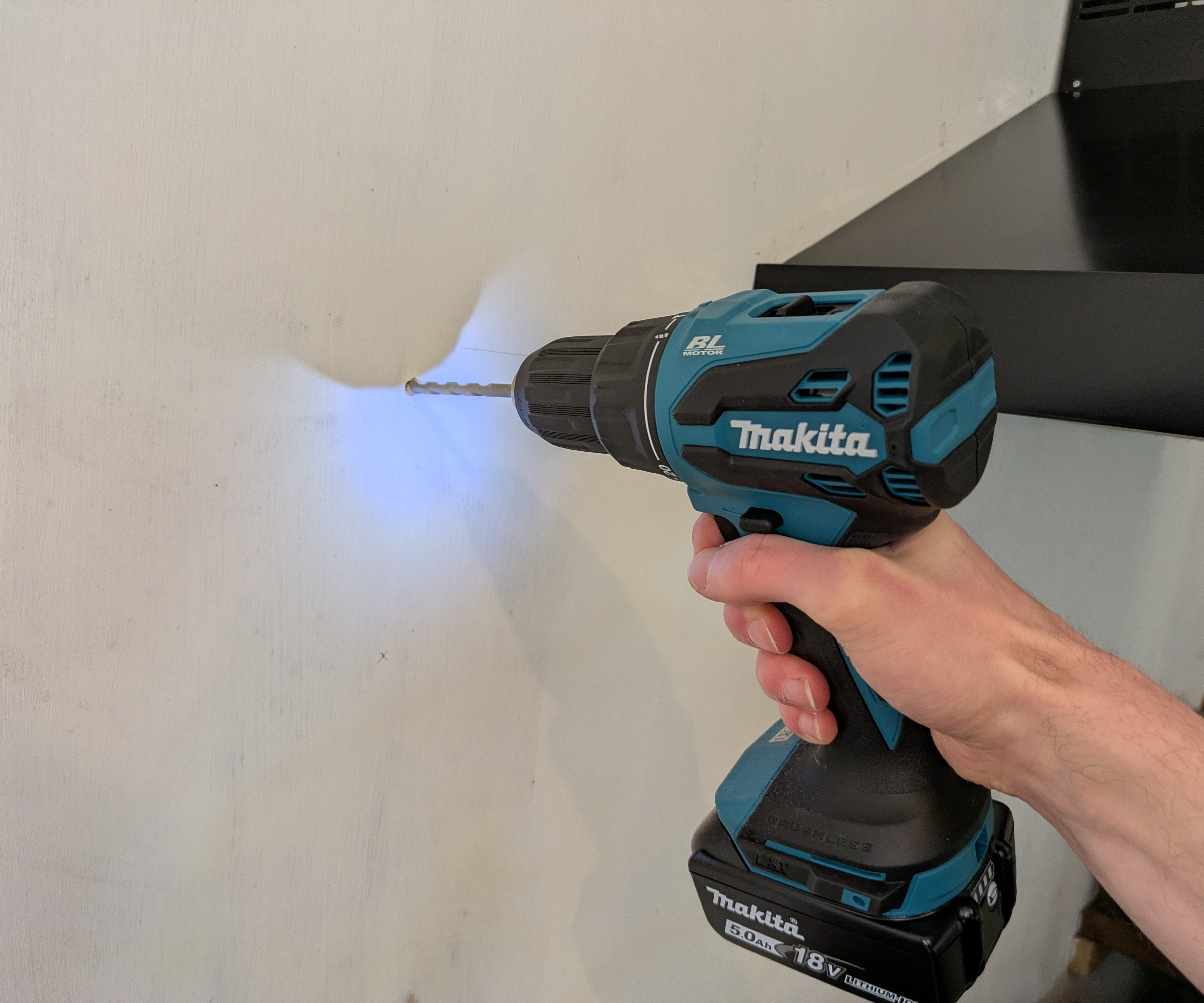 A drill drilling into a wall