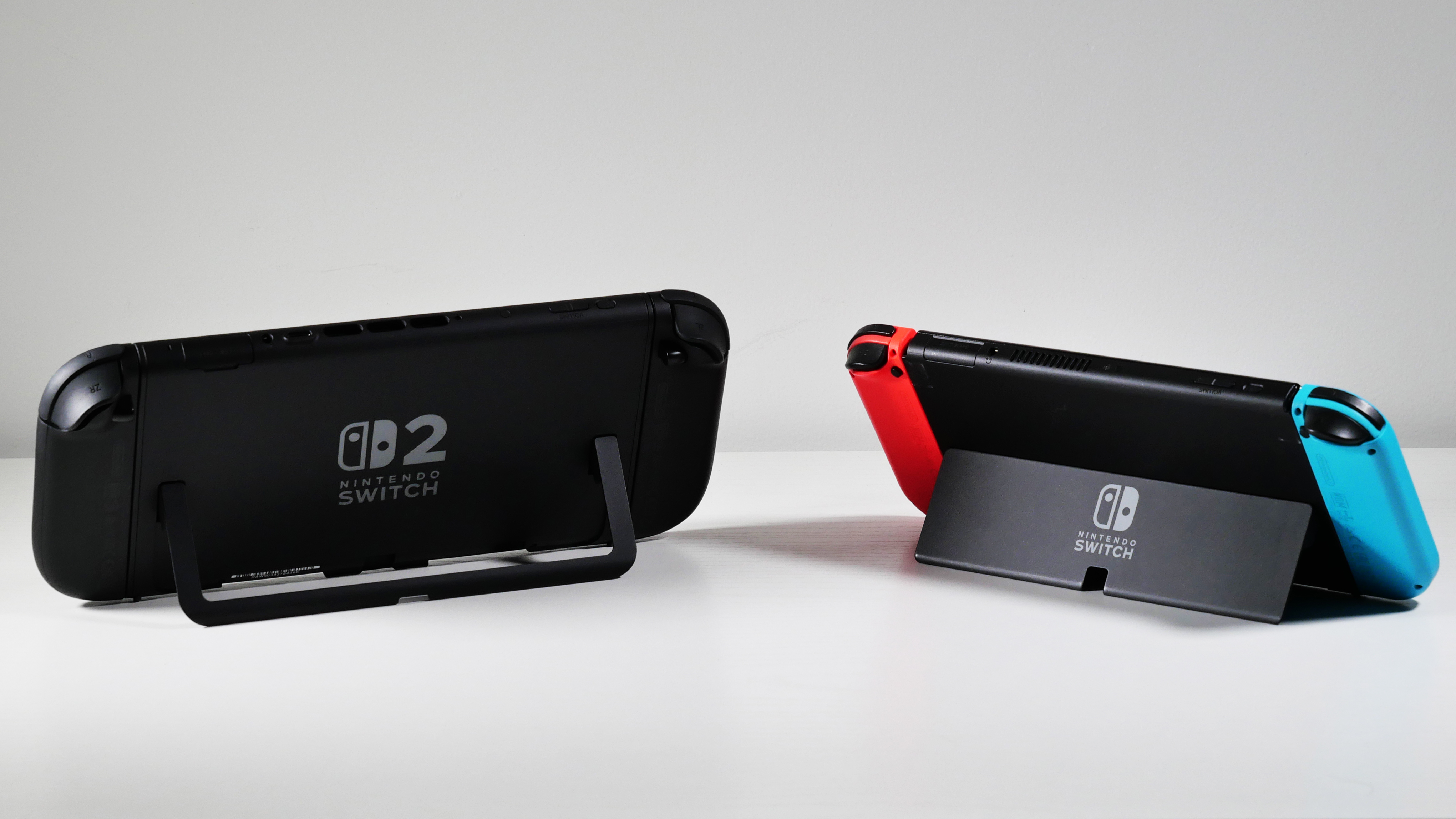 Nintendo Switch 2 and Switch OLED side by side, highlighting their kickstands.