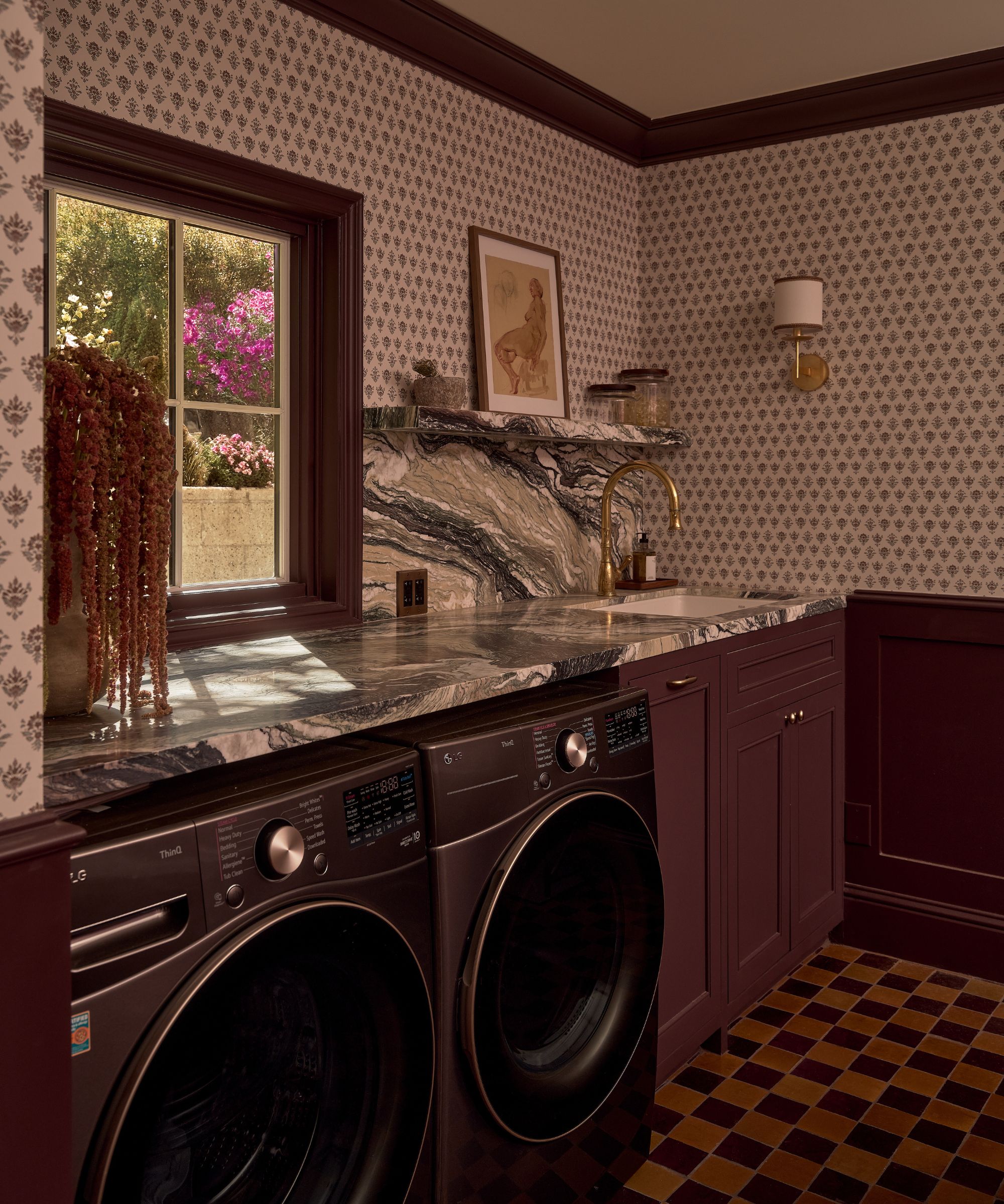 a purple painted laundry and mudroom with wallpapered walls, marble counters, and a checkered floor