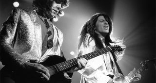 A black and white shot of Thin Lizzy guitarists Gary Moore and Scott Gorham both working their Les Pauls – Moore on the Junior, Gorham on a Standard.