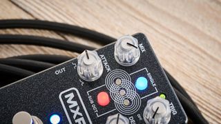 MXR Layers pedal in metallic black finish with clear controls pictured on wood floor with coiled guitar cable