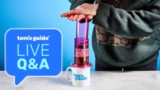 a person using an aeropress with a tom's guide branded mug and a tom's guide live q&a logo