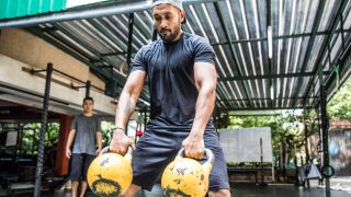 Man exercising with two kettlebells