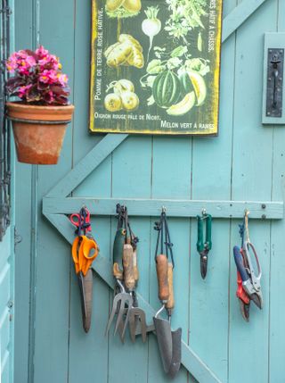 garden shed with garden tools hanging on the door