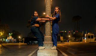Two friends hanging on to a light post in Booksmart