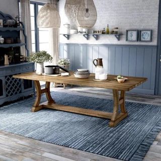 A long wooden dining table in a blue kitchen